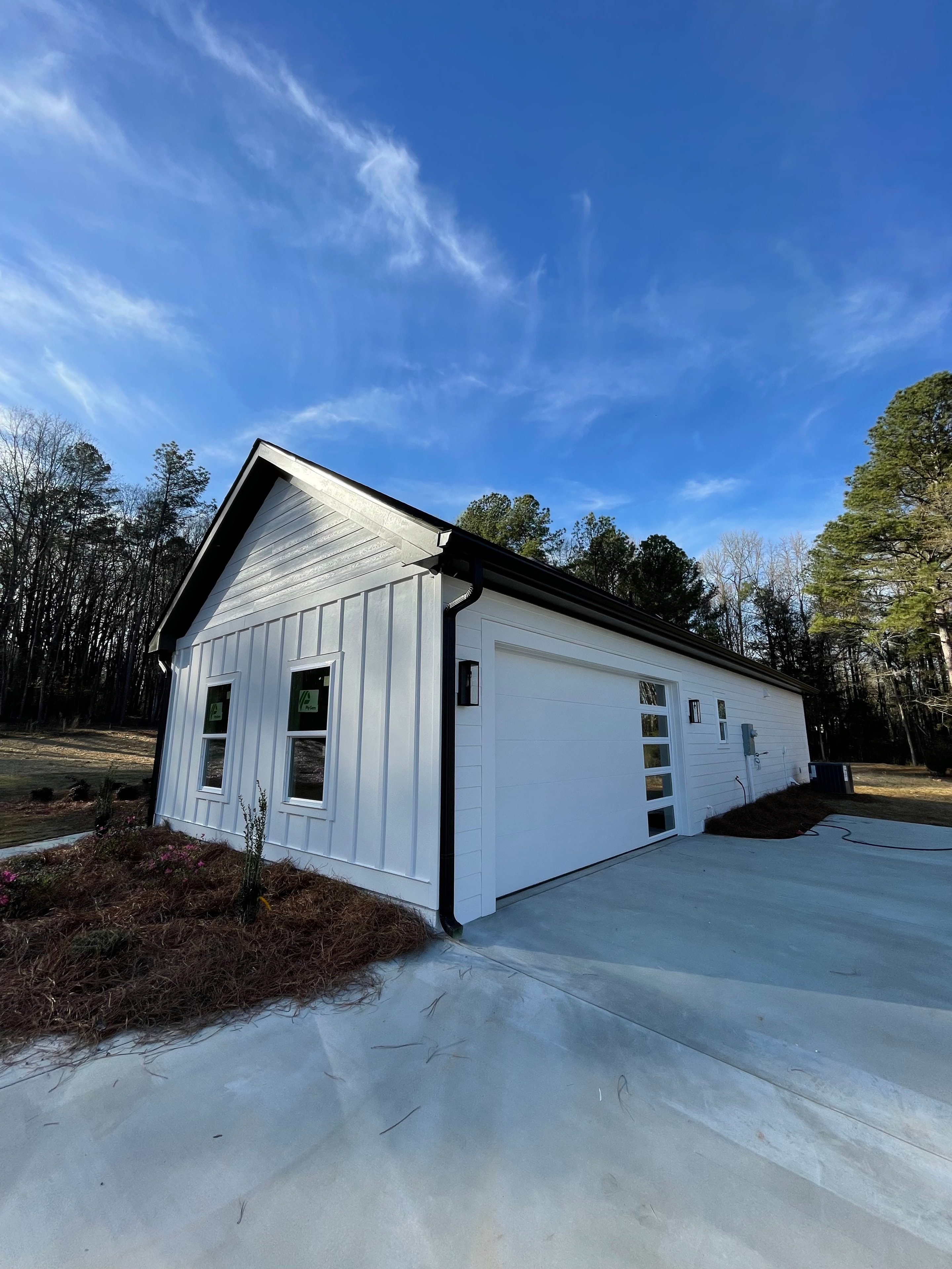 White farmhouse exterior with black trim and gutters