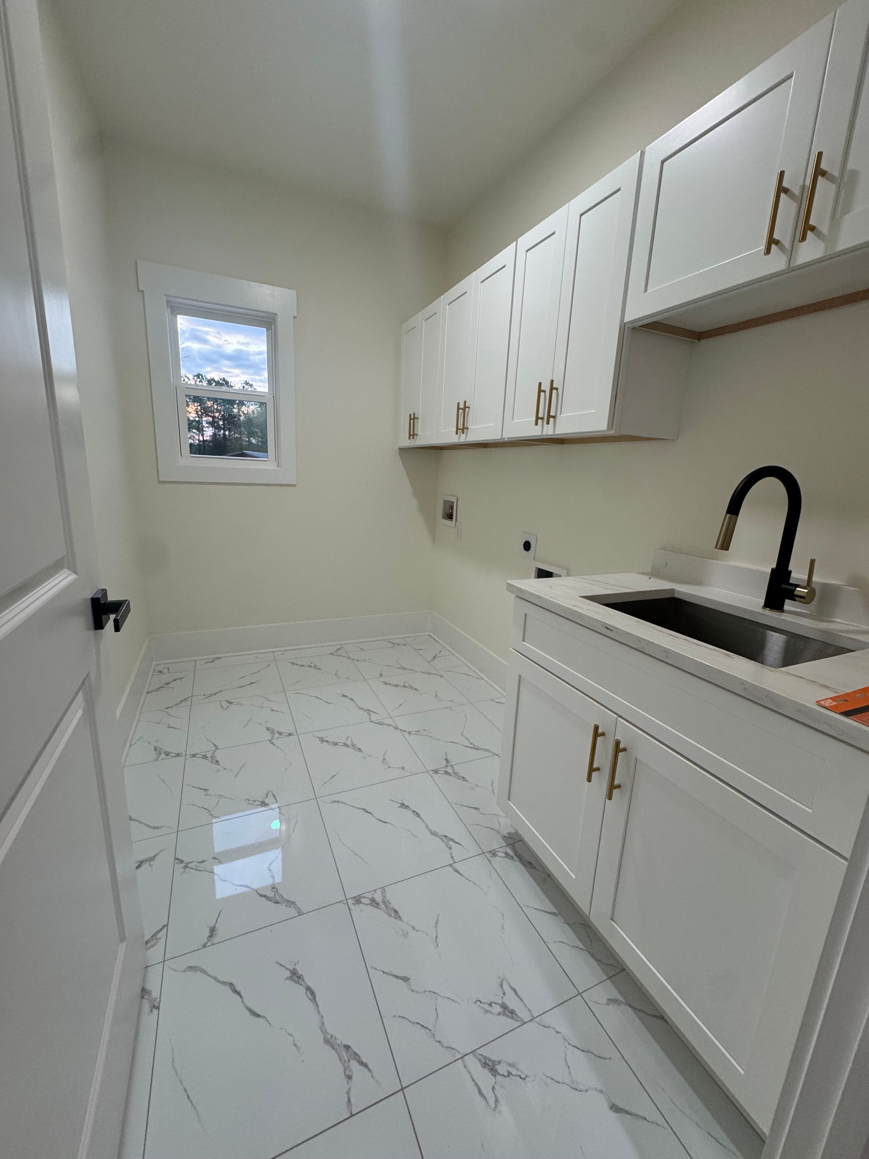 White kitchen cabinets with marble tile and gold hardware